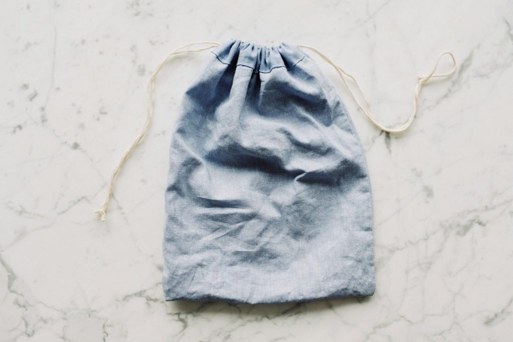 Top view of blue empty fabric reusable bag with white drawstrings placed on marble surface in light room Easy Way to Make Coffee Without Coffee Maker
